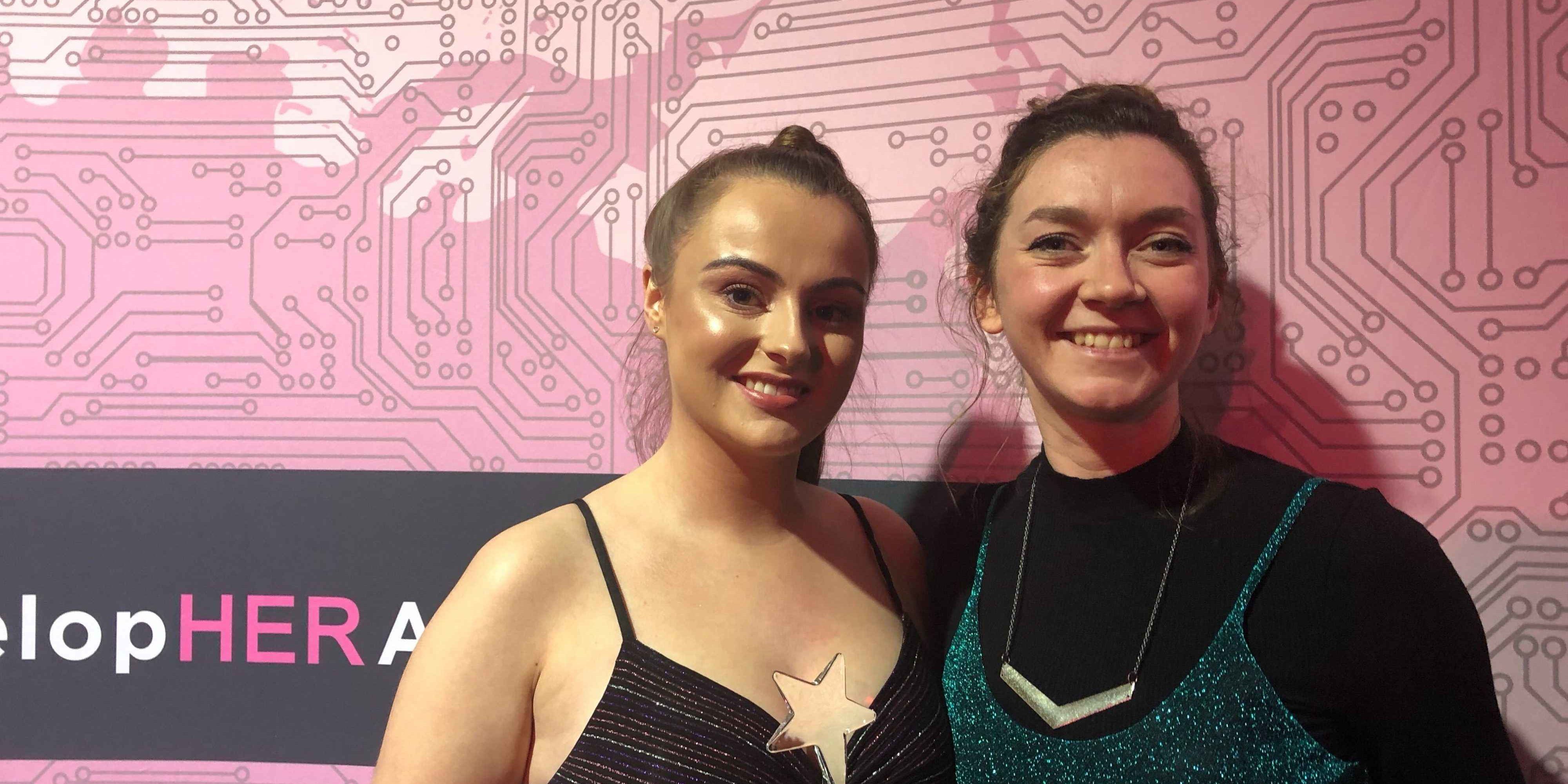 Eva and Ellie at the DevelopHer Awards. Eva is holding her award which is a silver star. 