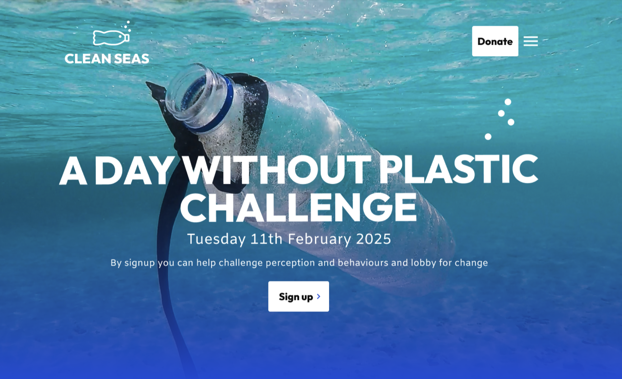 Homepage header with a background image of a plastic bottle floating in a light blue sea. The main focal point of this image is in the centre. On top of the background is a white logo (top left), a white donate link and hamburger menu icon (top right), and white hero text and a sign up link (in the centre).